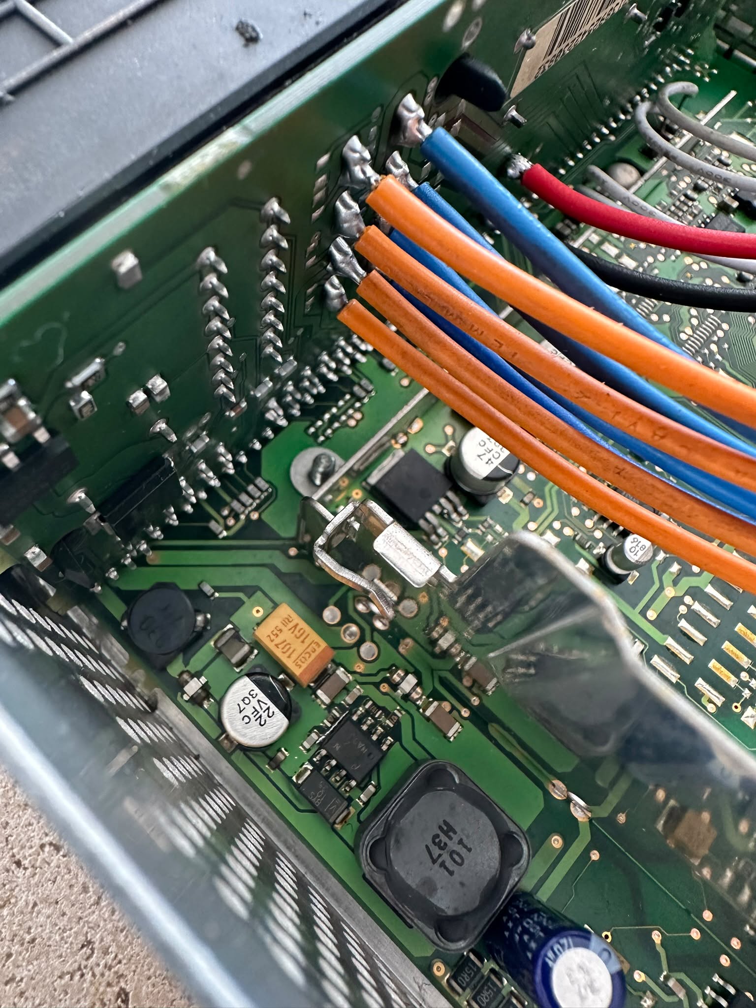 Geöffnete Audioelektronik mit Leiterplatte und verlöteten farbigen Leitungen