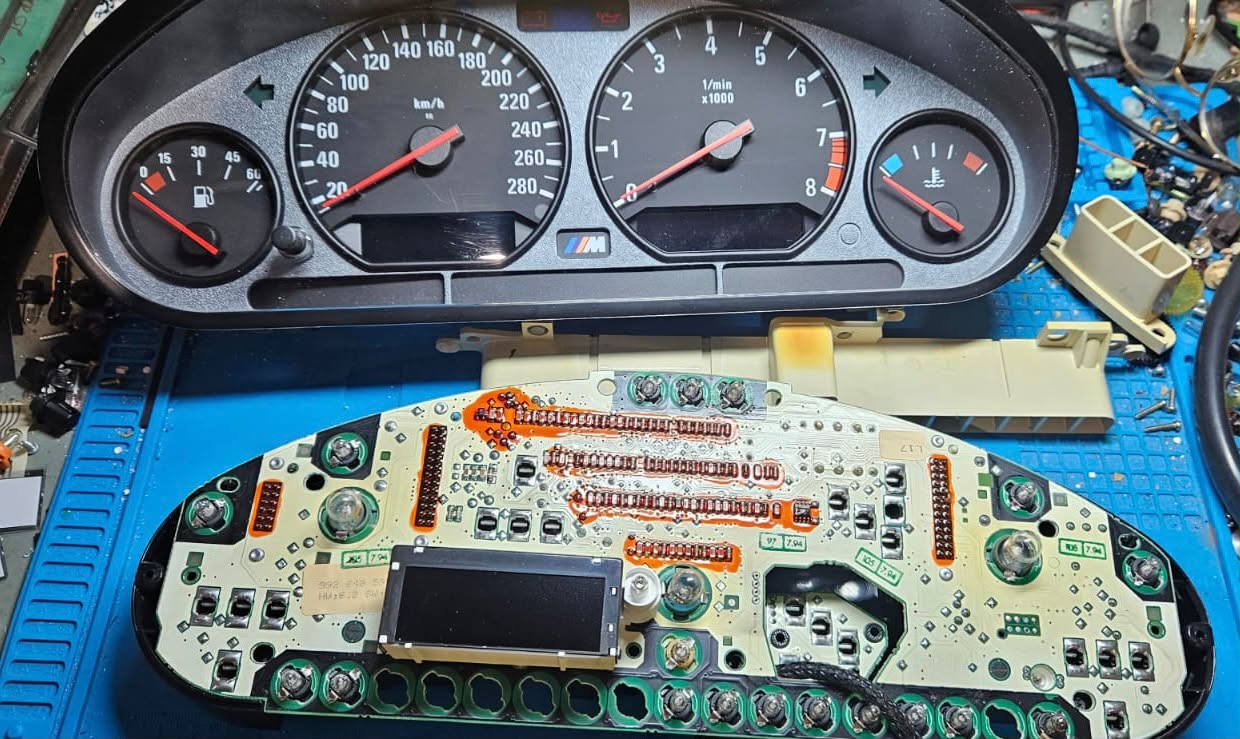 Historisches BMW-Kombiinstrument mit offener Platine auf der Werkbank