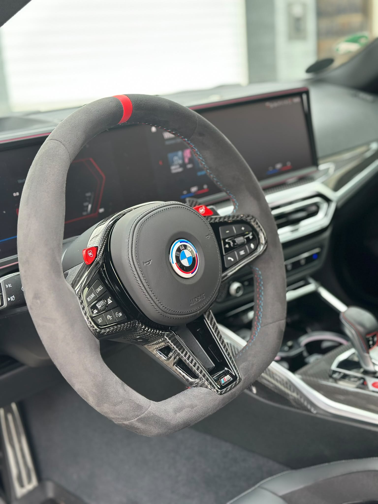 BMW-Lenkrad mit grauem Bezug, roter Markierung und Carbon-Details